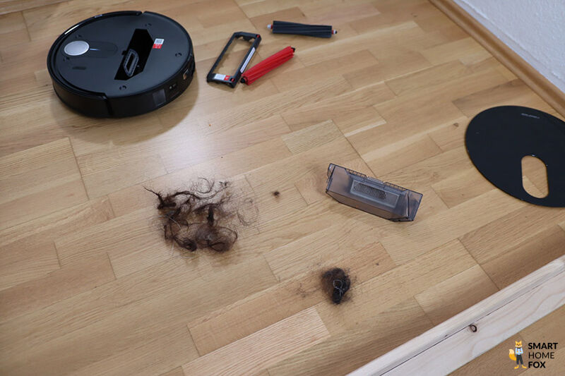 Haare liegen neben dem Roborock QRevo Slim